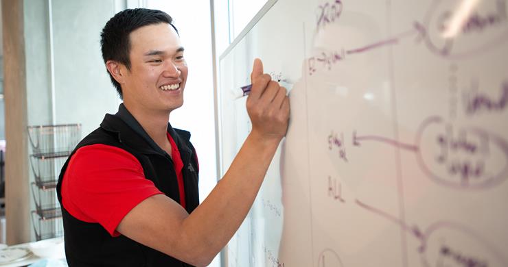 Male Intern Writing on Whiteboard
