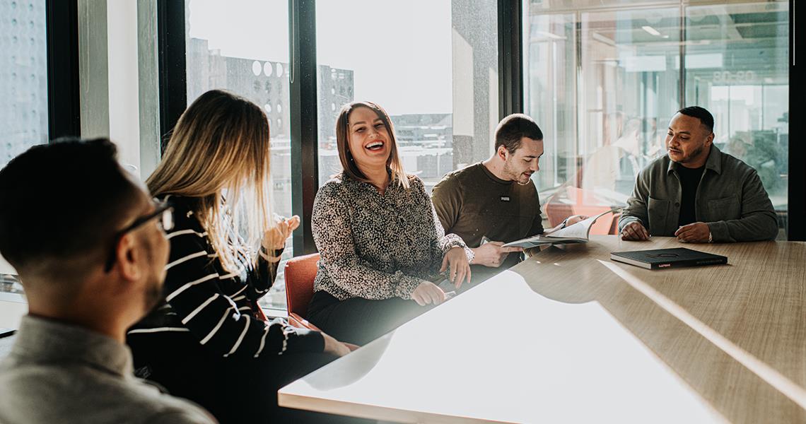 Team Laughing and Discussing Around Table