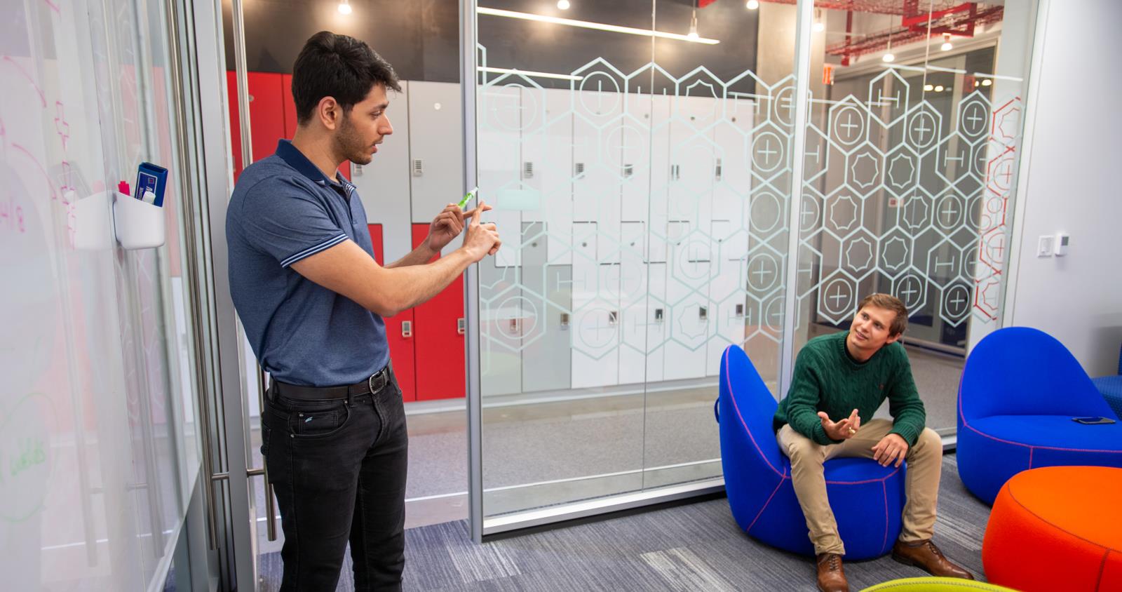 Two Males Discussing a Topic on Whiteboard