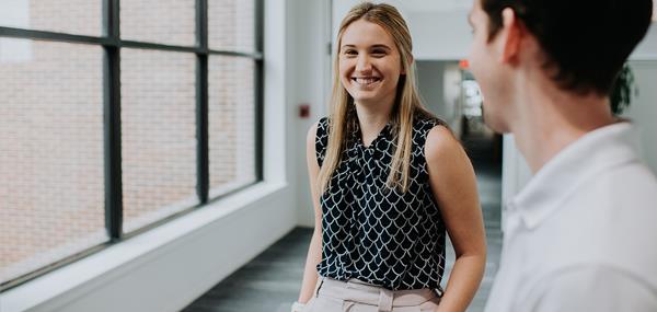 Two Recent Graduates Walking Down Hall Together