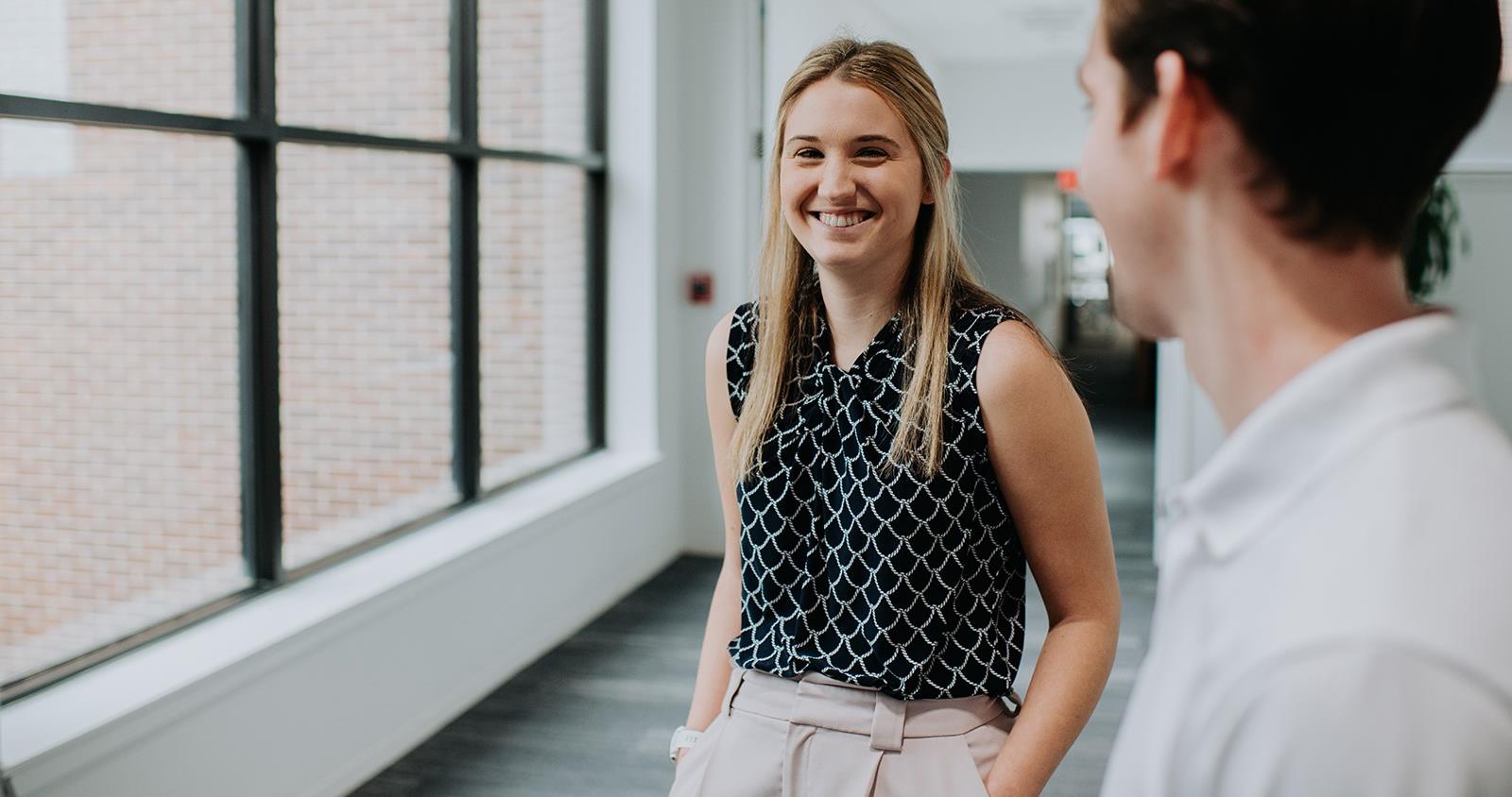 Two Recent Graduates Walking Down Hall Together