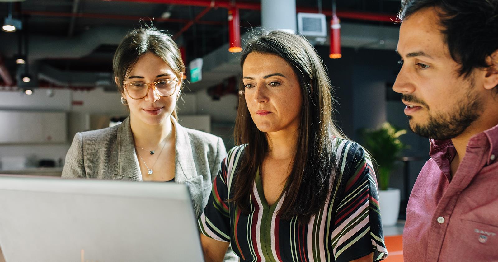 Three Team Members Looking at a Computer Together